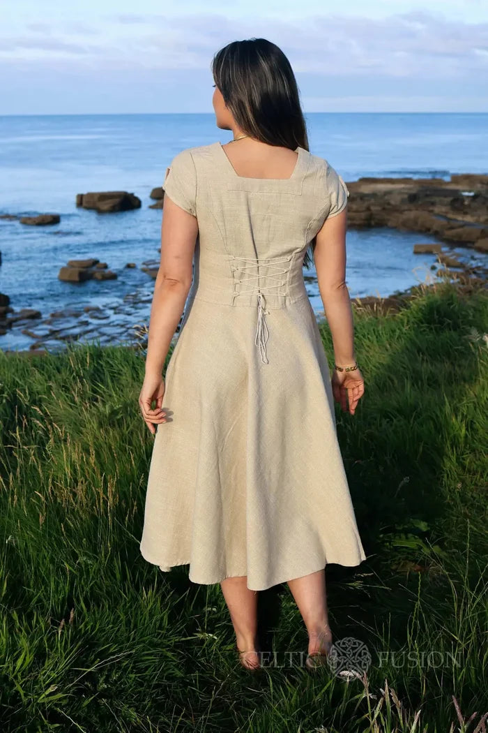 Back view of beige midi cottagecore dress with corset back, photographed by the sea in soft evening light designed by Celtic Fusion