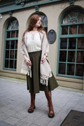Handwoven cotton shawl in natural beige with fringe detail and Celtic knot embroidery trim worn as a wrap