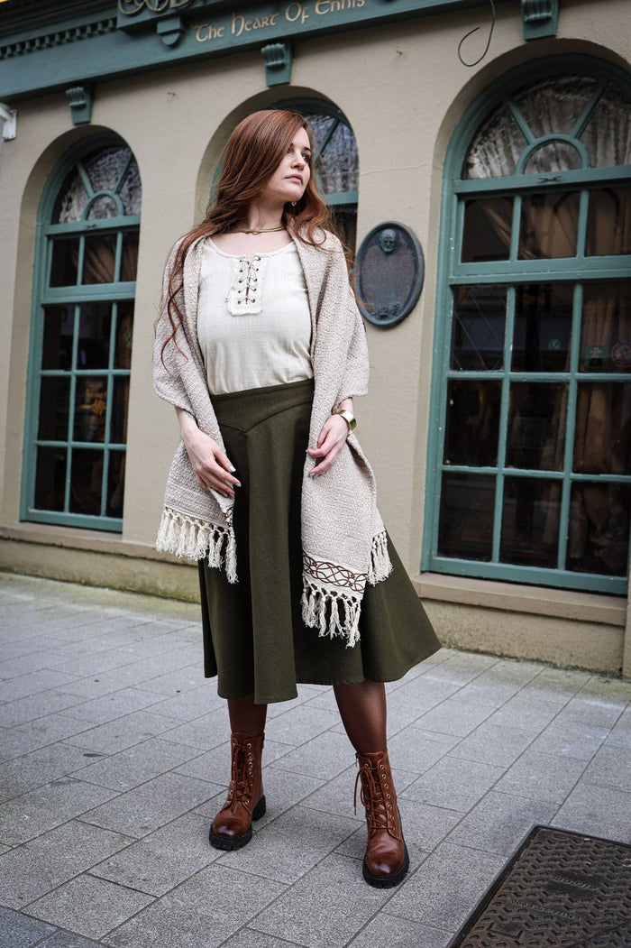 Handwoven cotton shawl in natural beige with fringe detail and Celtic knot embroidery trim worn as a wrap