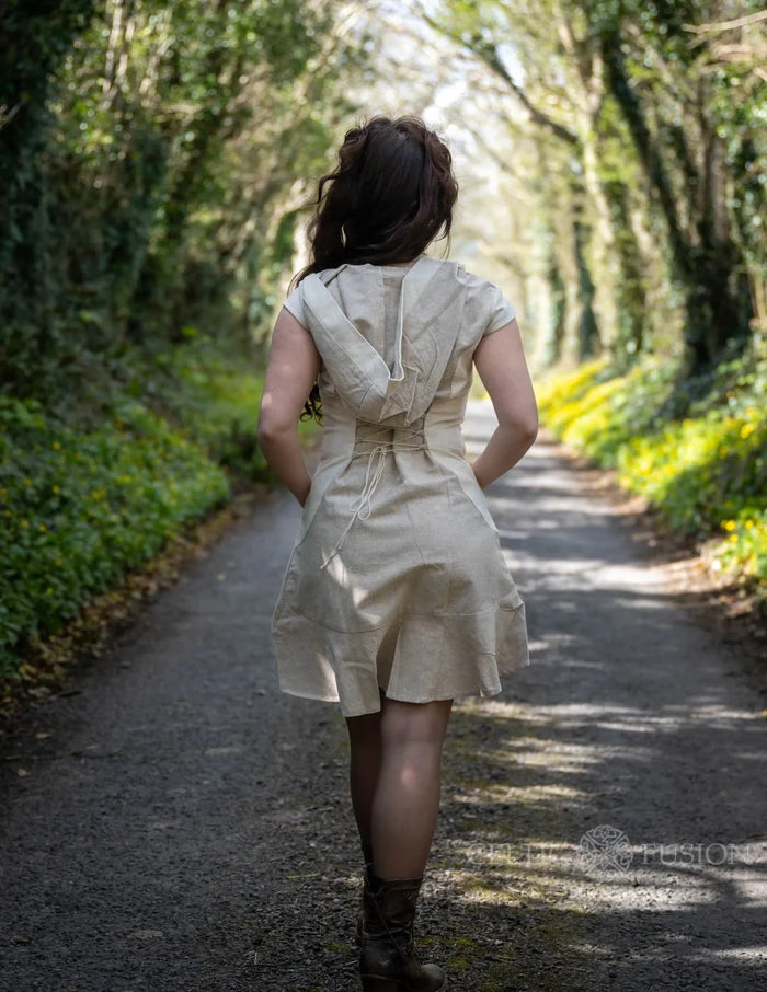 Beige corset-back mini dress showing the relaxed hood, lace-up waist and contrasting natural cotton panels