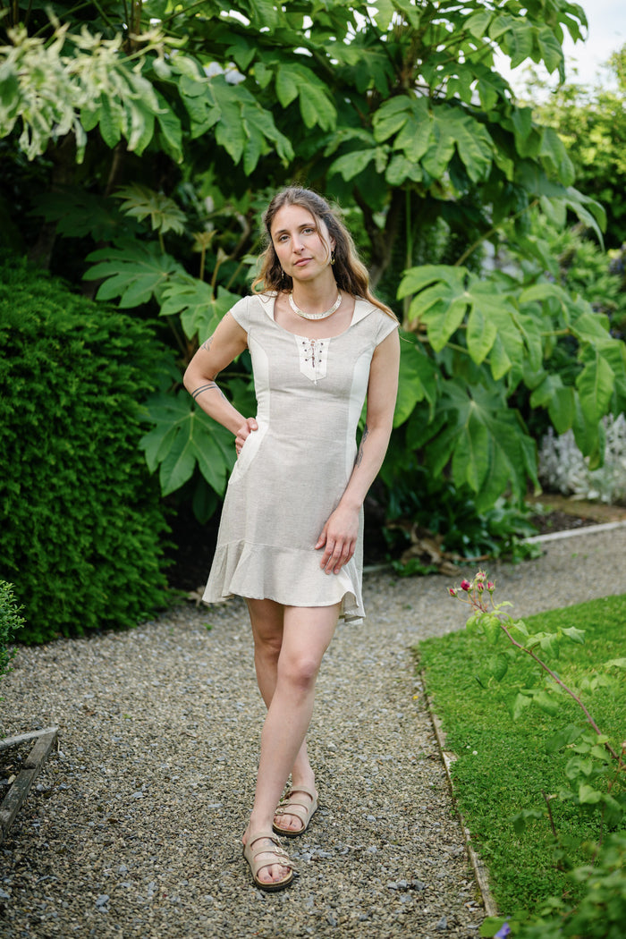Beige hooded dress with pockets, lace-up neckline and softly flared mini hem in breathable cotton