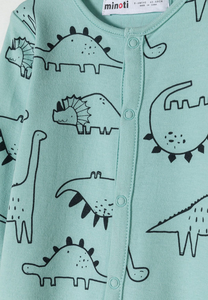 Detail of a mint long sleeve sleepsuit for boys with dinosaur print and press stud fastening.