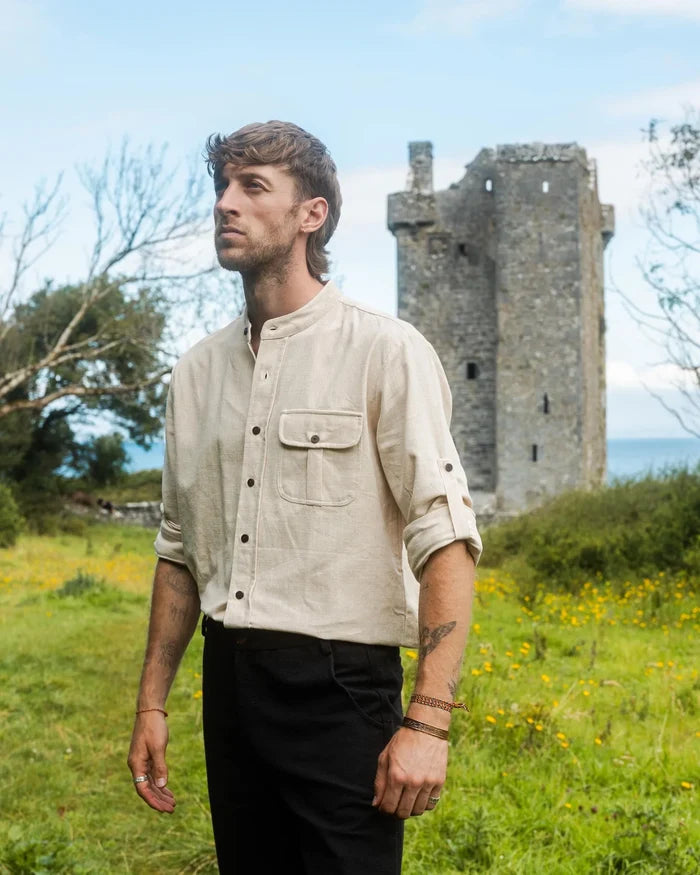 Men’s alternative wedding shirt in undyed white cotton slub, shown from the side with collarless neckline and rustic heritage folk styling
