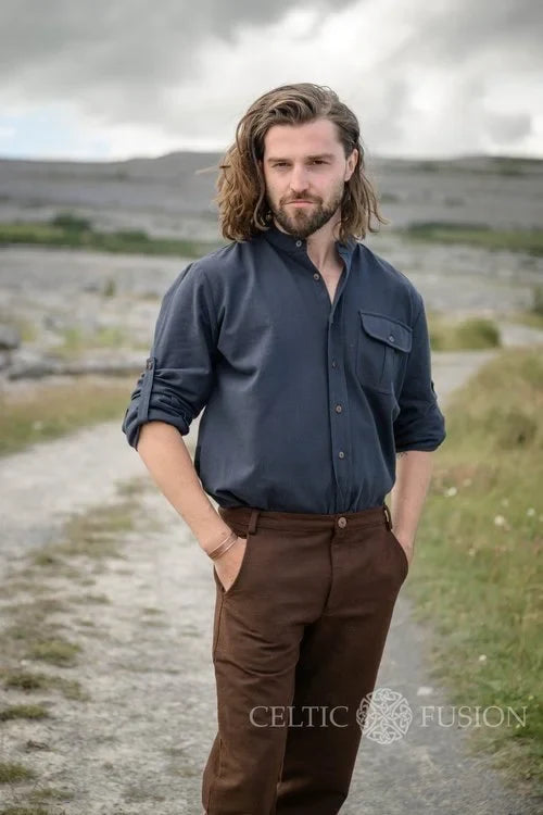 Celtic collarless dress shirt for men in midnight blue, styled outdoors as a button down shirt with rollable sleeves and a chest pocket