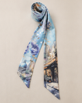 Hamida silk twilly scarf rolled neatly with pastel blue floral and cityscape design