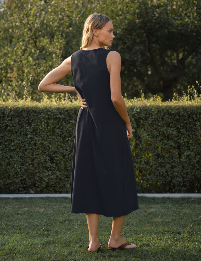 Woman in a navy dress standing in a garden