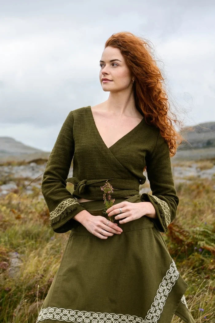 Elva Celtic Wrap Crop Top in olive green with a crossover V-neckline, adjustable waist tie and Celtic embroidered bell sleeves.