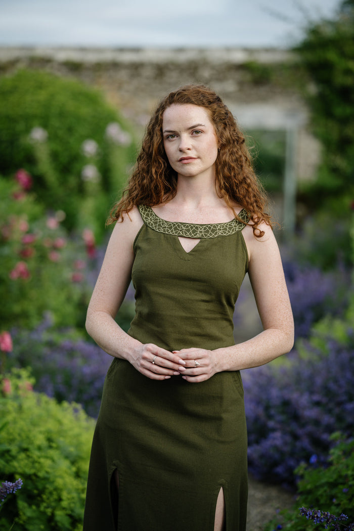 Green Celtic dress with slit front and pockets, styled outdoors with a full skirt and embroidered neckline