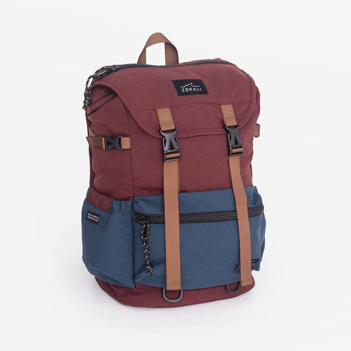 Two-tone red and blue backpack with brown straps on a white background