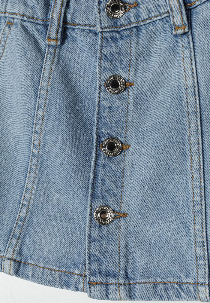 Detail of a light blue denim skirt featuring button fastening and decorative stitching.