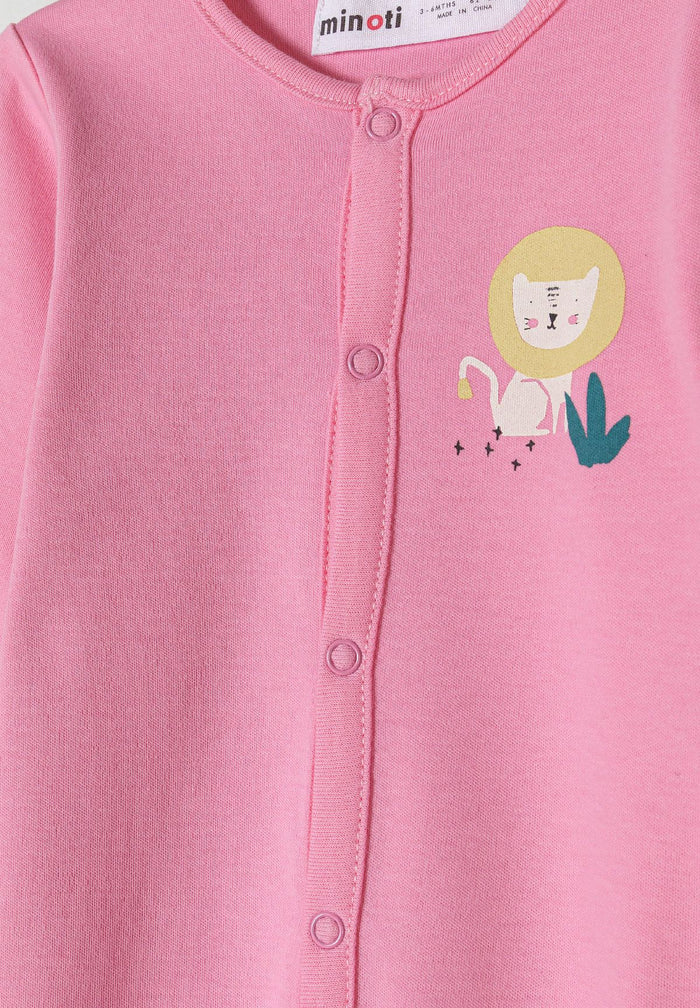 Detail of a pink baby pyjama with a lion print and front press stud fastening.