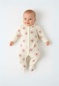 Front view of a long-sleeved light pink sleepsuit for girls with floral pattern and integrated feet.