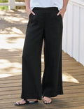 Person wearing black wide-leg pants on a wooden deck