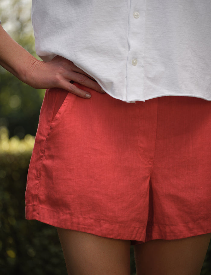 Person wearing a white shirt and red shorts with a blurred background