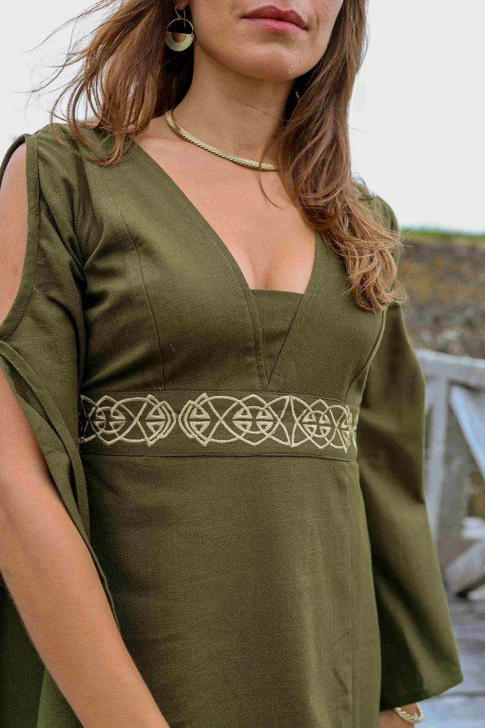 Close-up of the Maeve Celtic Dress showing deep V neckline, olive green cotton slub fabric and Celtic knot embroidery at the waist.
