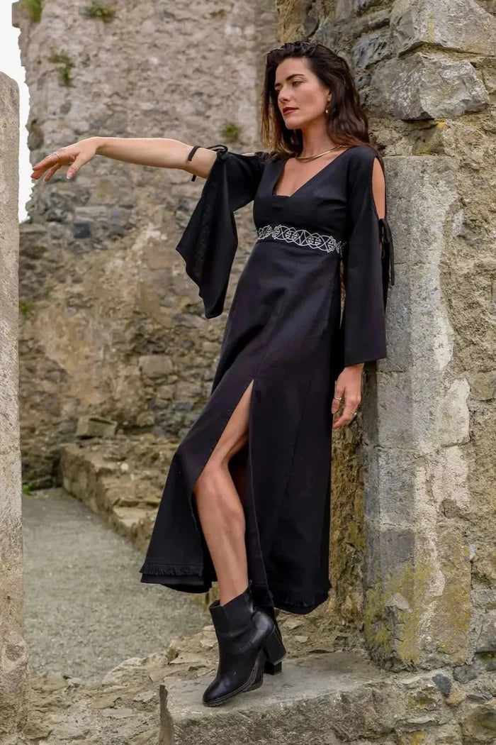 Side view of Maeve Black Celtic Dress, gothic folklore dress in black cotton slub with flowing sleeves and embroidered waist
