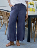 Person wearing navy wide-leg pants and a white top in an outdoor setting.