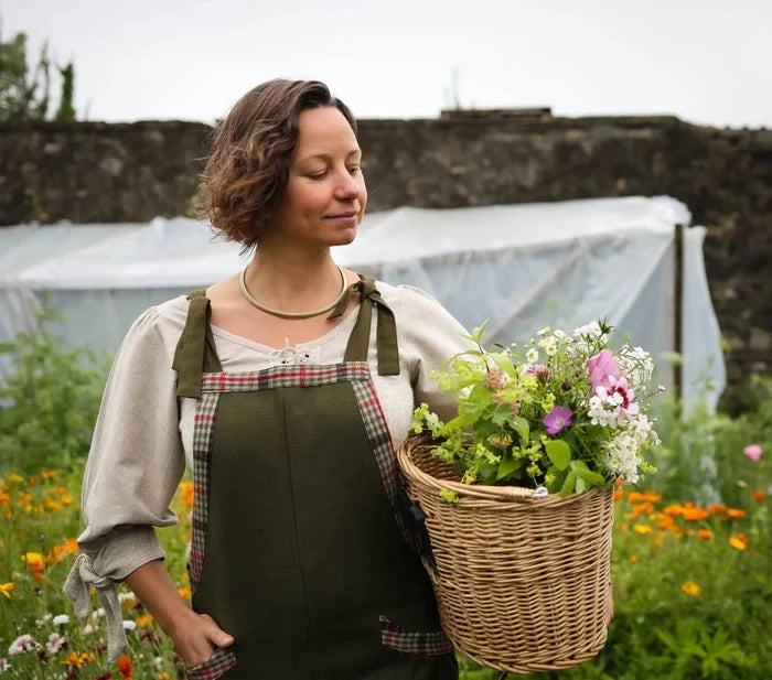 Relaxed cottagecore Green overalls with tweed check details worn in a flower garden with a flower basket