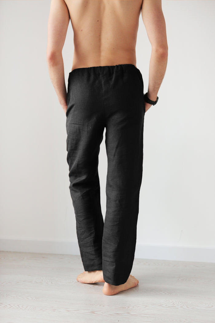 Man wearing black linen pants against a plain background