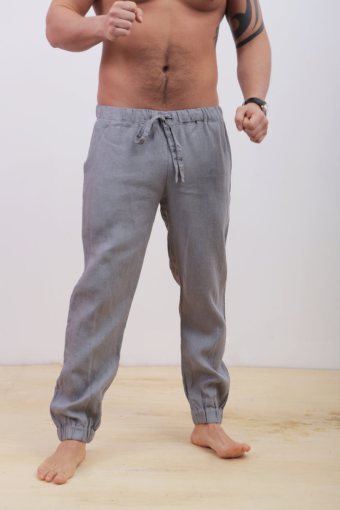 Person wearing gray jogger pants on a plain background