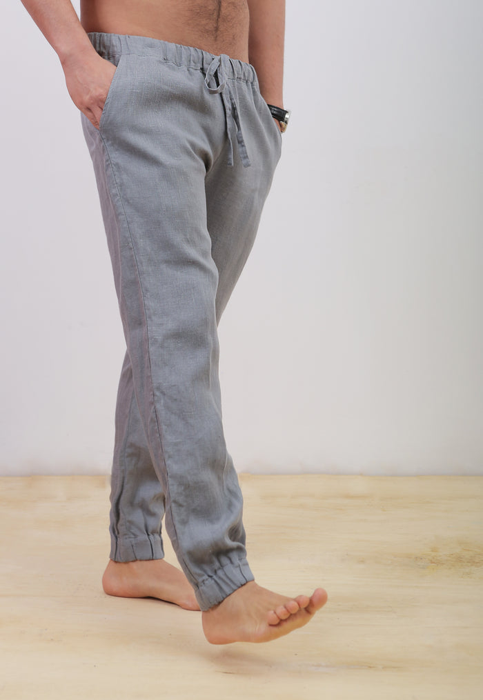 Person wearing light gray jogger pants on a plain background