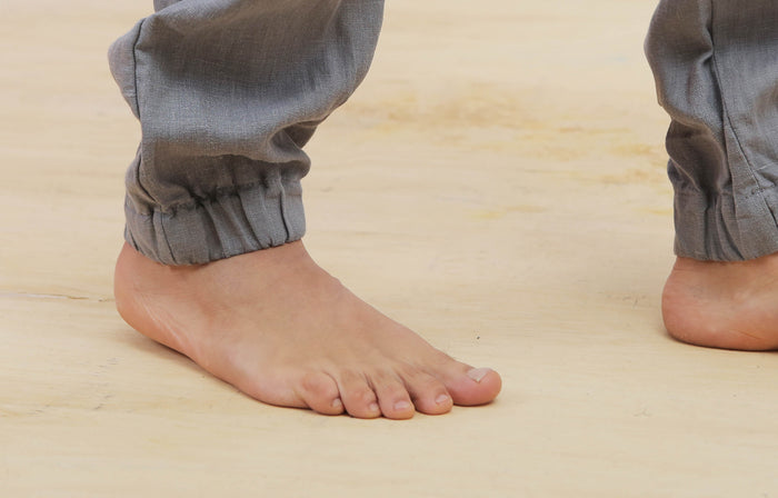 Close-up of a person's bare feet on a wooden floor