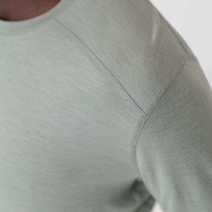 Man wearing a light green long-sleeve Merino shirt on a white background