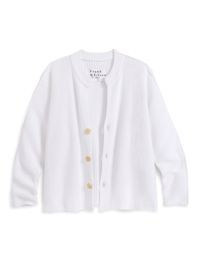 White cardigan with buttons on a black background