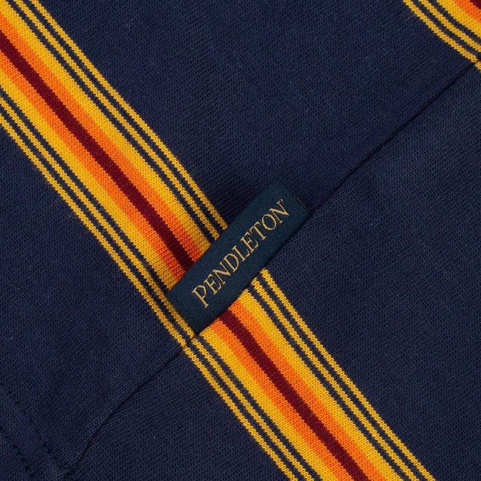 Close-up of a Pendleton fabric label sewn onto a navy blue garment with bold yellow, orange, and burgundy striped detailing.