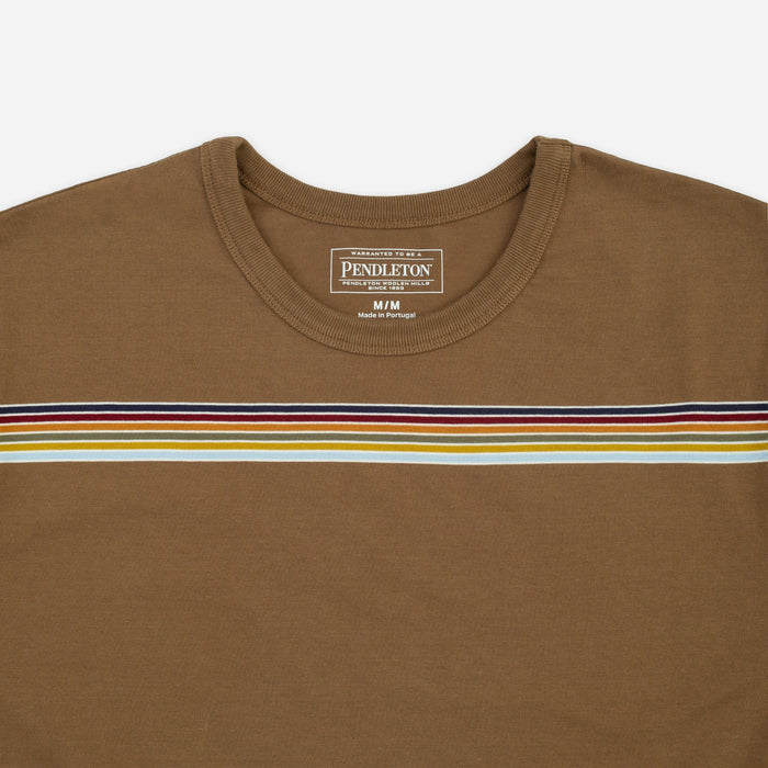 A close-up of a Pendleton brown crewneck t-shirt featuring a horizontal stripe pattern across the chest in navy, red, yellow, and white.