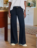 Person wearing navy wide-leg pants in a home setting