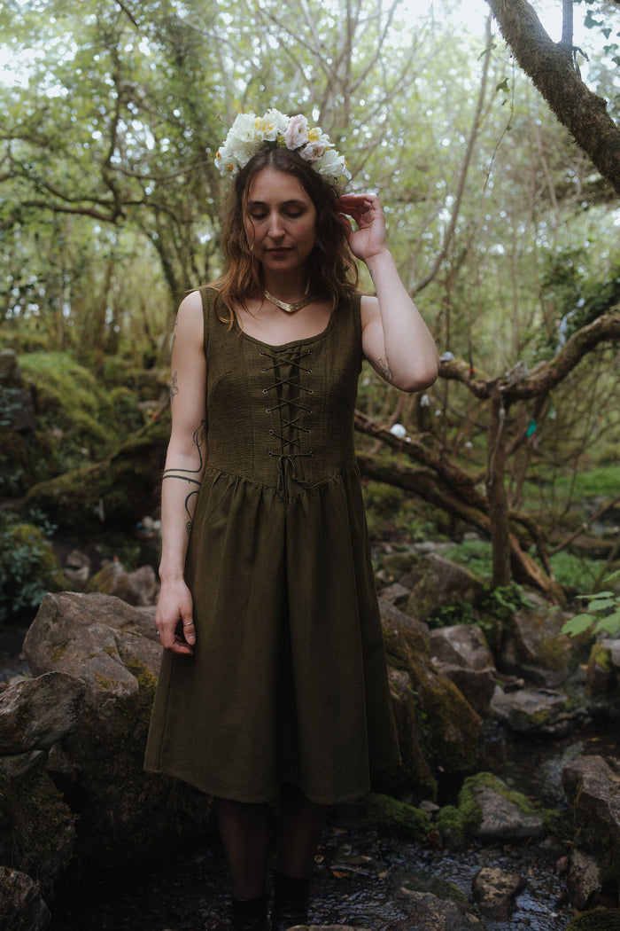 Rosemary Green Corset Dress, dark green folklore dress with pockets styled in a woodland setting with floral crown