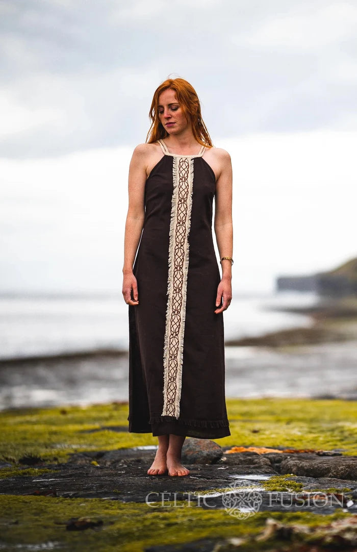 Sleeveless Brown Celtic Dress styled on the shoreline with long flowing shape and Celtic knotwork front panel