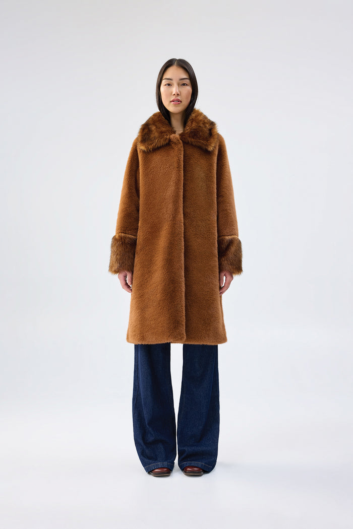 Brown faux fur coat with contrasting darker brown collar and cuffs, mid-length relaxed fit, worn over dark wash wide-leg jeans, front view