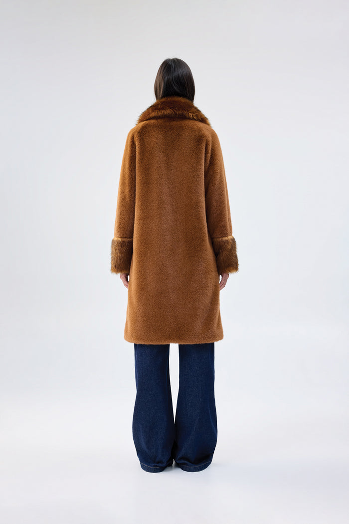 Brown faux fur coat with contrasting darker brown collar and cuffs, mid-length relaxed fit, worn over dark wash wide-leg jeans, back view